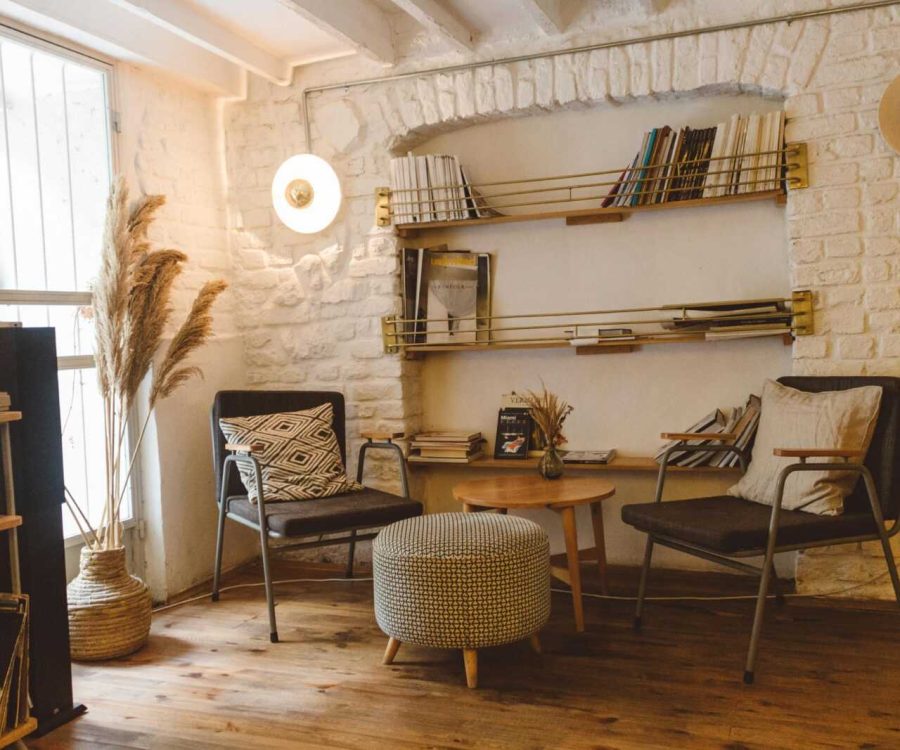 Inviting modern rustic living room featuring armchairs, an ottoman, and a stylish bookshelf.